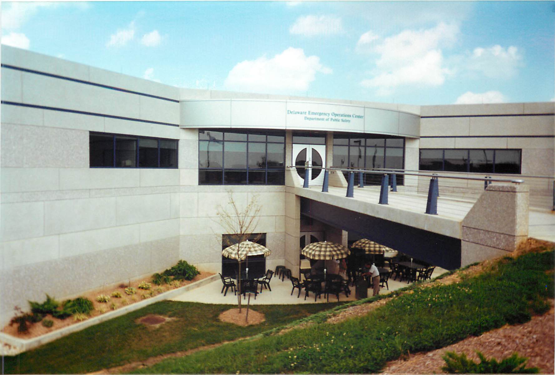 The entrance to the DEMA building, with outdoor tables and umbrellas for employees.
